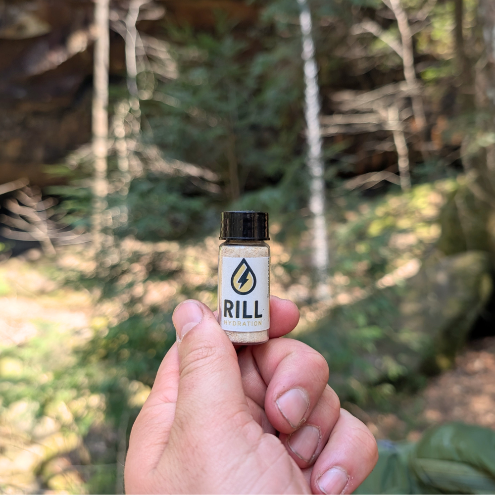 hand holding small vial of Rill Hydration Pineapple Electrolyte Drink Mix in a single serving. Great for on the go hydration even in the great outdoors 